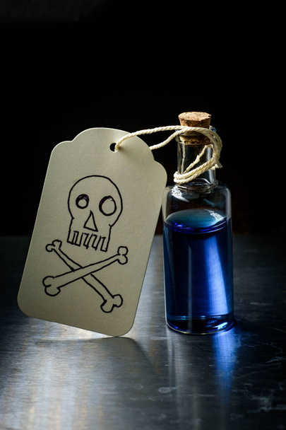 Skull and crossbones paper tag labels bottle of poison - Photo, Image