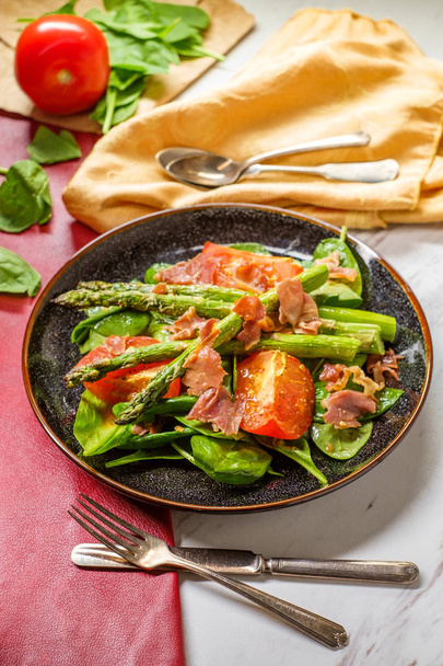 Kızarmış domates, ıspanak yaprağı ve balzamik sirke soslu kuşkonmaz salatası. - Fotoğraf, Görsel
