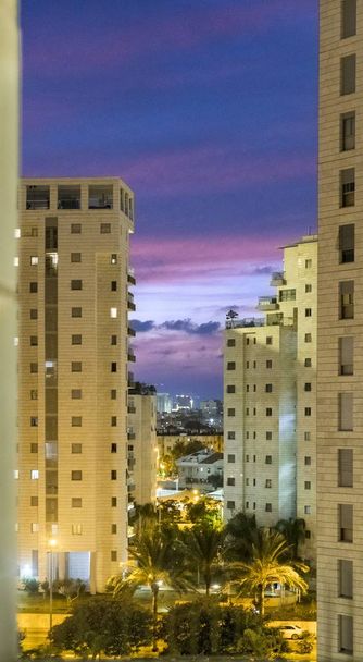 Ηλιοβασίλεμα το βράδυ σε μια μεγάλη σύγχρονη πόλη με ψηλό σπίτι - Φωτογραφία, εικόνα