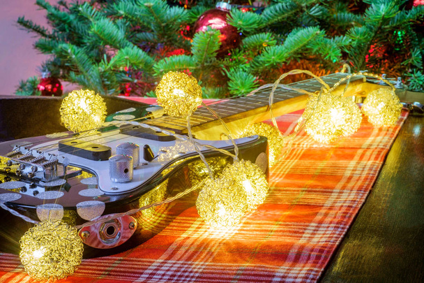 Szezonális holiday hangszer ukulele a karácsonyfa háttér - Fotó, kép