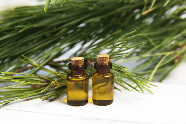 Pine essential oil and glass drops on white background - Foto, imagen