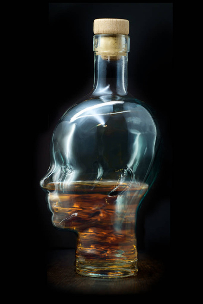 Alcoholisme concept glas hoofd als fles gevuld met whisky - Foto, afbeelding