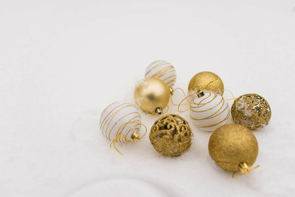 Composición navideña. Bolas de Navidad, adornos dorados, blancos y plateados sobre un fondo blanco
 - Foto, imagen