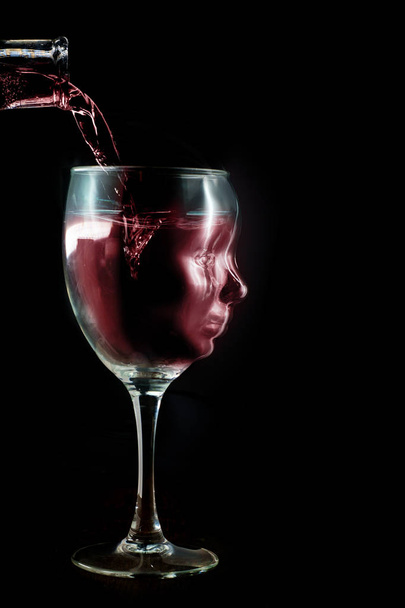 Wine glass has a face as though the wine takes the place of the addicts brain - Photo, Image