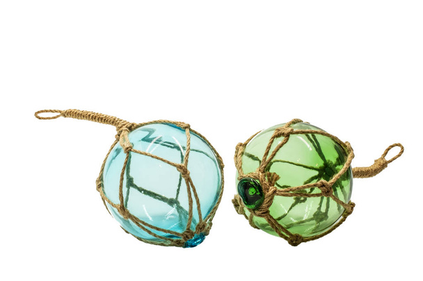 transparente skandinavische Dekor blaue und grüne Glaskugel in Seilen isoliert auf weißem Hintergrund - Foto, Bild