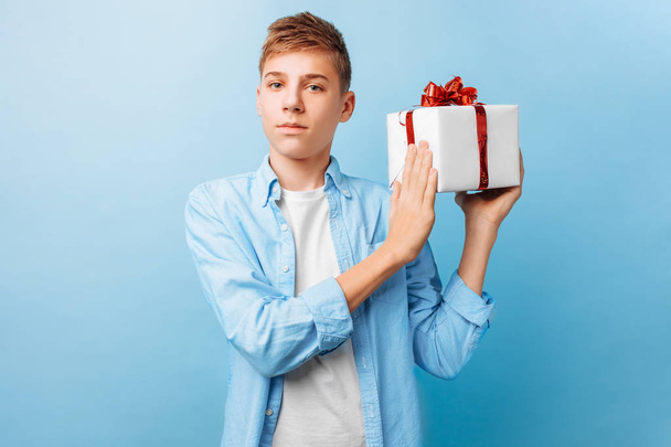 guy with a gift in his hands for Valentine's Day, on a blue background - Foto, afbeelding