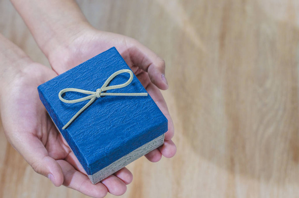 manos ofreciendo y sosteniendo regalo, cajas para regalo de lujo - Photo, Image