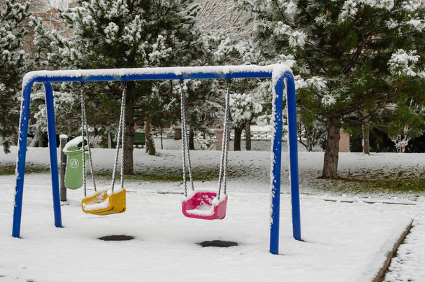 Paisagem de inverno com árvores cobertas de neve e parque infantil no parque
. - Foto, Imagem