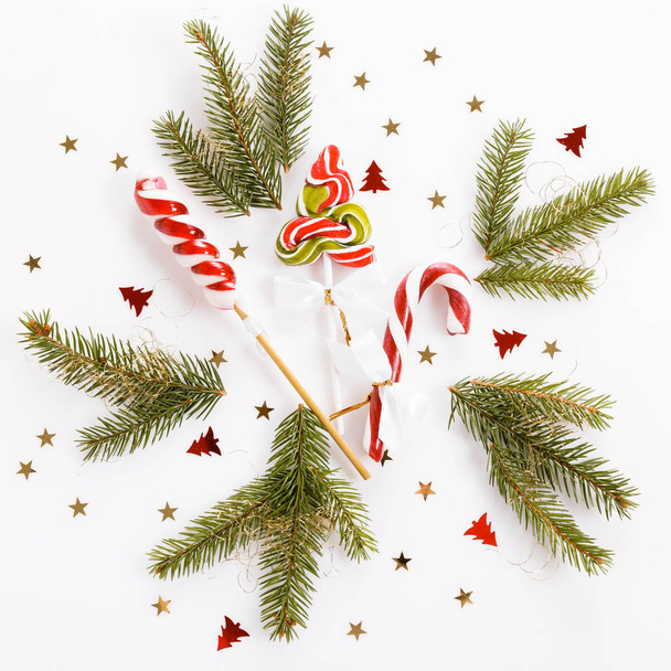 Composición navideña. Decoración rosa de Navidad, bastón de caramelo de Navidad con cinta sobre fondo blanco
. - Foto, imagen