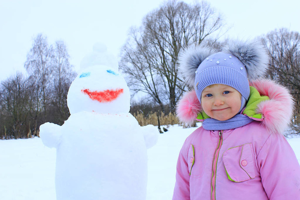 Portrait of smiling baby in amusing winter cap with two funny ears. Little girl and snowman head. Little girl made snowman. Winter fun kids - Photo, Image