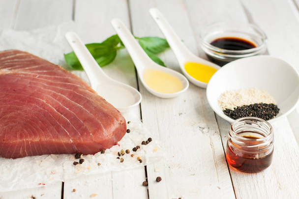 Raw tuna steak with condiments, preparation of seafood dish - Фото, изображение