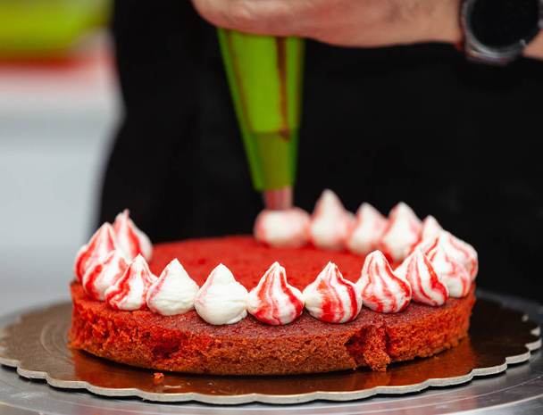 Punainen sametti kakku valmistelu. Se koostuu kirnupiimästä tai etikkakomponentista, joka aktivoituu ruokasoodalla, jotta se olisi erittäin pörröinen tai samettinen.
. - Valokuva, kuva