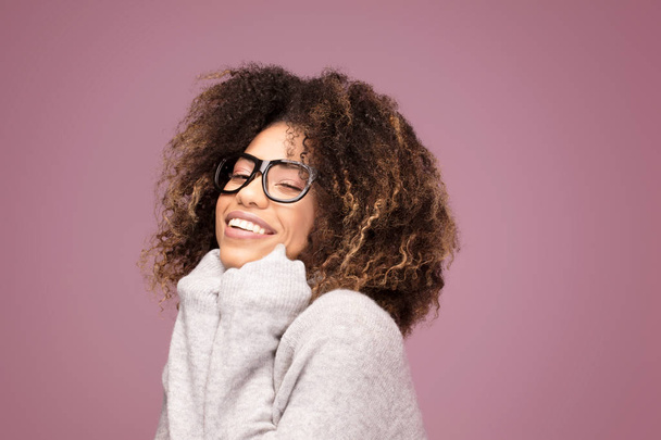 Young afro american woman wearing glasses over pink background smiling . - 写真・画像
