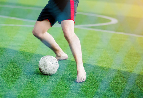 Voetballers niet dragen van een sport shirt en barefoot Ken snelheid uitvoeren om te schieten de bal naar het doel op groen kunstgras. Voetballers vechten elkaar door te schoppen de bal. - Foto, afbeelding