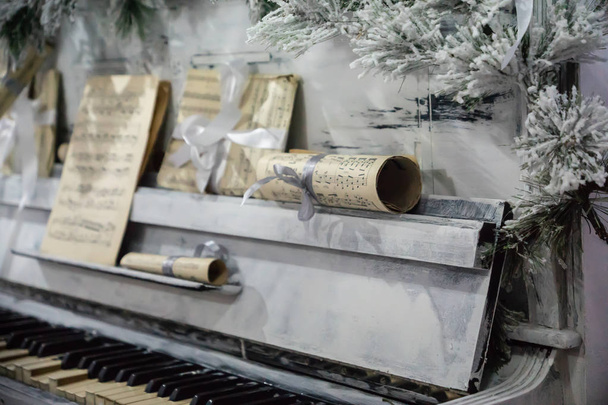 Piano bajo el árbol de navidad ramas y notas
 - Foto, Imagen