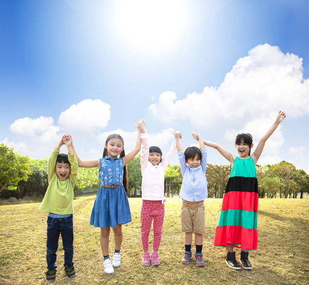 szczęśliwy wieloetnicznej grupie dzieci w wieku szkolnym w parku - Zdjęcie, obraz