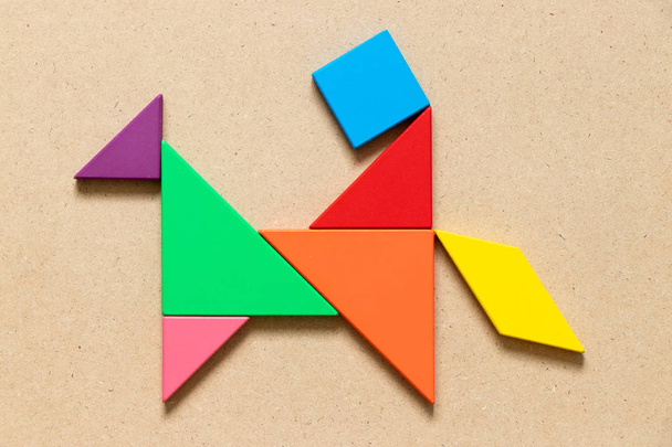 Barva tangram puzzle v člověka jezdit koně obrazce na pozadí - Fotografie, Obrázek