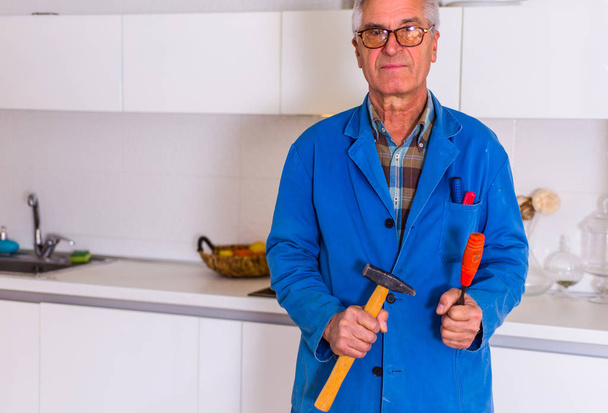 Vanhuus yleismies tilalla hänen työkalu keittiössä ja työ
 - Valokuva, kuva