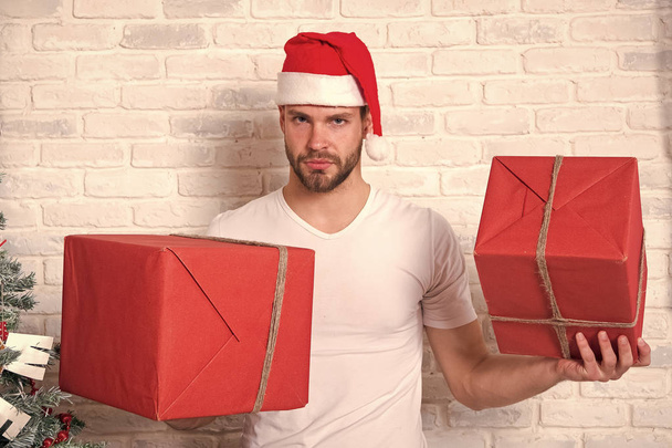 Man santa with boxes on white brick wall - Foto, afbeelding