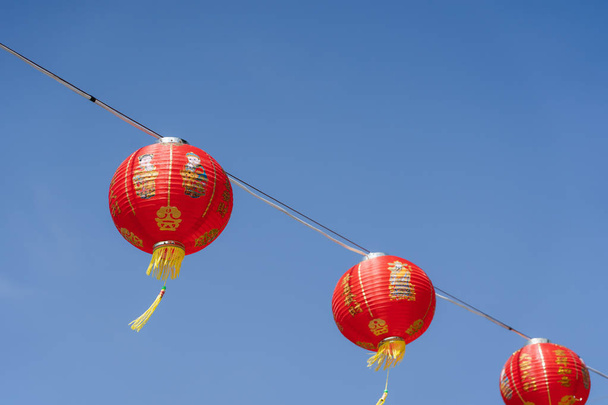 Chinese language mean rich or wealthy and happy.shot of arrangement decoration Chinese new year & lunar new year holiday background concept.China lantern hanging on beautiful blue sky on outdoor. - Photo, Image