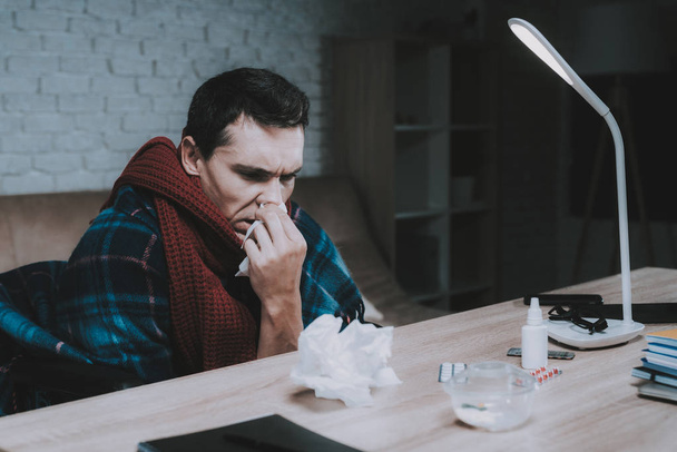 Disabled Sick Young Man on Wheelchair at Home. Man on Wheelchair. Disabled Guy. Checkered Blanket. Healthcare Concept. Freelancer with Cold. Sick Man. Healthcare at Home. Wooden Table. - 写真・画像
