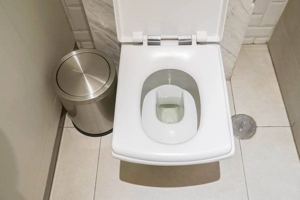 top view of white ceramic toilet bowl in toilet with stainless bin in bathroom - Photo, Image
