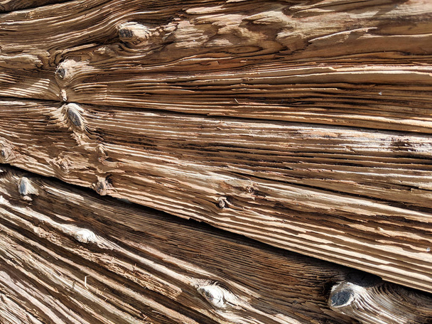 verwitterte Holzwand aus geteilten Baumstämmen mit Augenhöhlen, strukturierter natürlicher Hintergrund - Foto, Bild