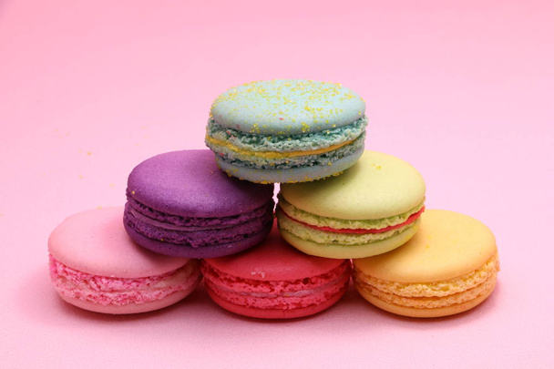 Colorful cake macaron or macaroon on pink background from front view, colorful almond cookies, pastel colors, vintage card - Photo, Image