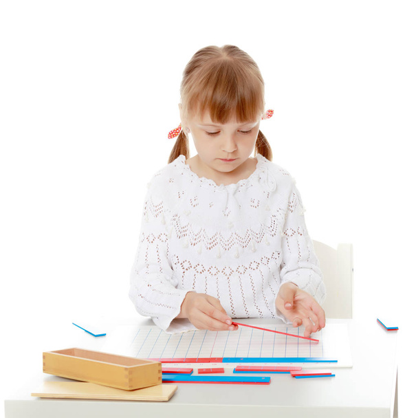 A little girl is studying Montessori stuff. - Zdjęcie, obraz