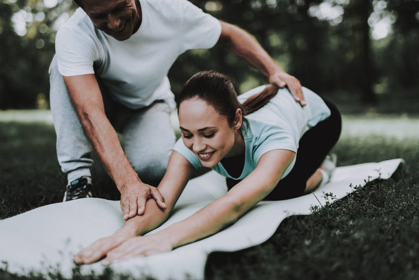 Young Couple in Sportswear Doing Exercises in Park. Sport and Healthcare Concept. Young Man Outdoor. Summer Park. Fun Outdoor. Sport in Summer. Trainer in Summer Park. Smiling Young Woman. - Foto, immagini