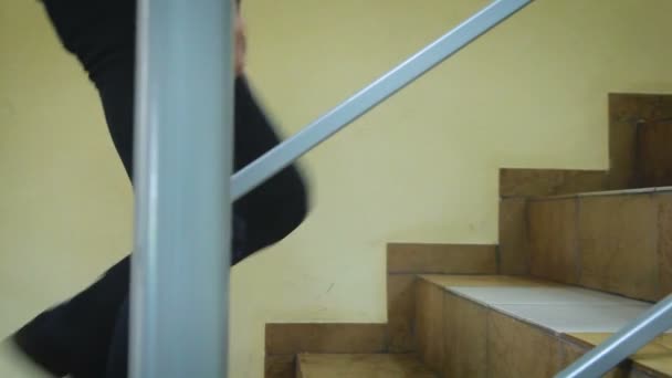 Ένας άνθρωπος ανεβαίνει τις σκάλες με ένα κιγκλίδωμα - Πλάνα, βίντεο