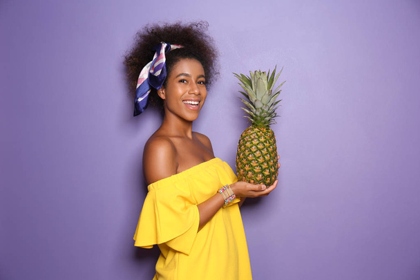 Beautiful African-American woman with pineapple on color background - Foto, immagini