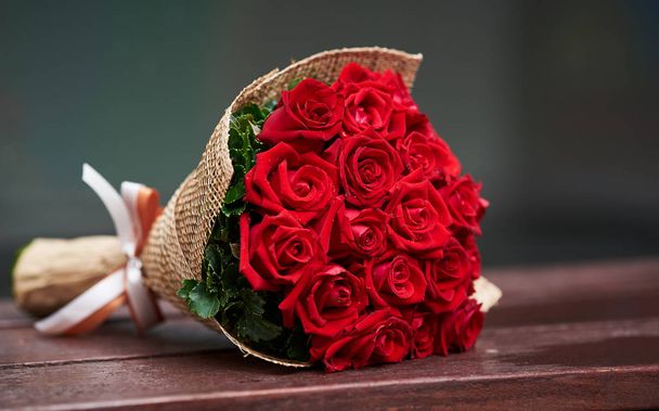 Piękny bukiet czerwonych róż na drewniane krzesło - Zdjęcie, obraz