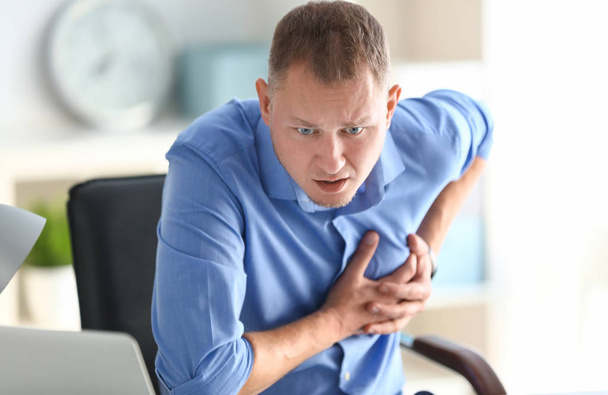 Man met paniekaanval op werkplek op kantoor - Foto, afbeelding