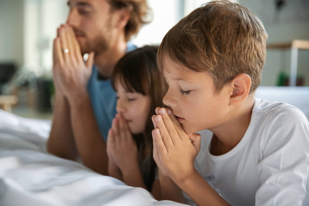 Familie betet in Bettnähe zu Hause - Foto, Bild