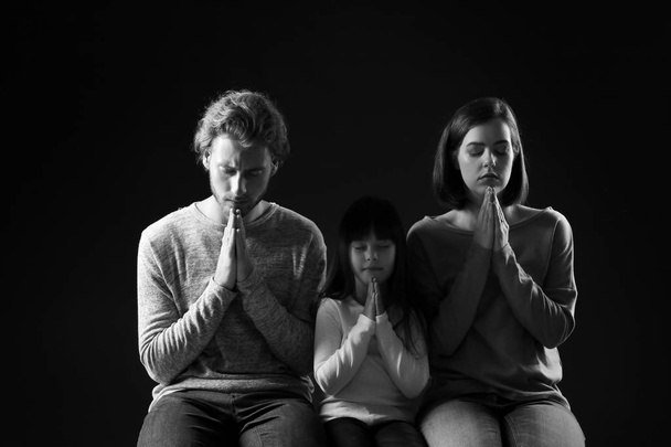 Imádkozó család sötét háttér - Fotó, kép