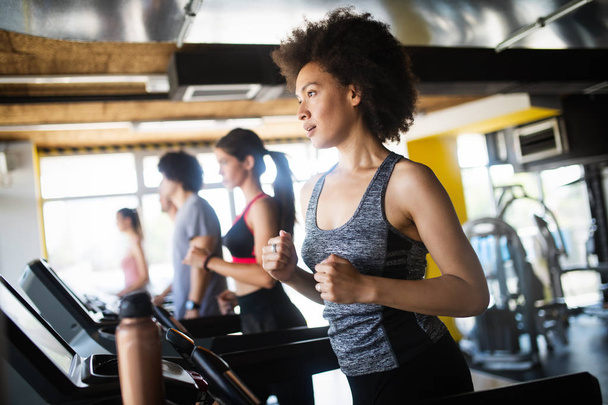 Fit happy people running in machine treadmill at fitness gym - Φωτογραφία, εικόνα