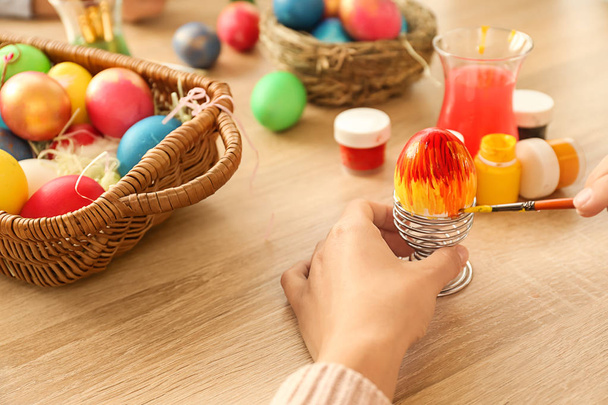 Mujer pintando huevos de Pascua en la mesa
 - Foto, imagen
