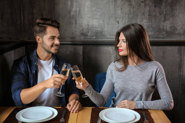 Pareja cariñosa con copas de champán en restaurante en cita romántica
 - Foto, Imagen