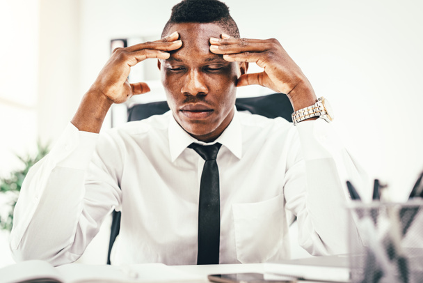 Anxious African businessman sitting in office - Photo, Image