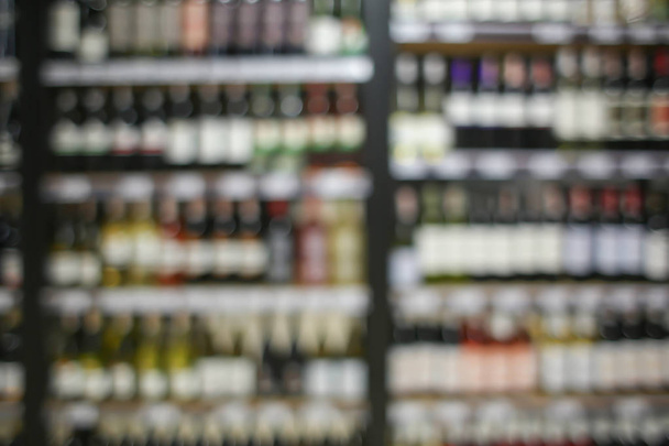 Размытый взгляд на различные алкогольные напитки на полках в магазине
 - Фото, изображение
