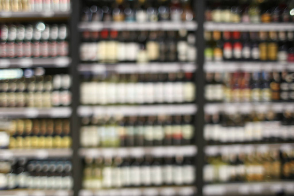 Vista turva de bebidas alcoólicas variadas em prateleiras na loja
 - Foto, Imagem