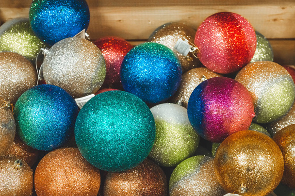 Venta de juguetes navideños en el supermercado. Bolas de diferentes colores para el árbol de Navidad en los estantes del supermercado. Juguetes de Navidad a la venta en la tienda. Variedad de bolas de vidrio
 - Foto, imagen