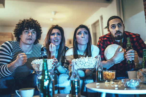 Gruppo di amici allegri che guardano la partita di calcio con la birra a casa
  - Foto, immagini