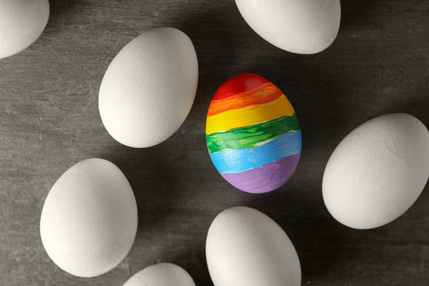 Веселка розмальовувала яйце серед білих на сірому фоні. концепція ЛГБТ
 - Фото, зображення