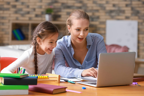 Cute girl with mother doing homework at home - Photo, Image