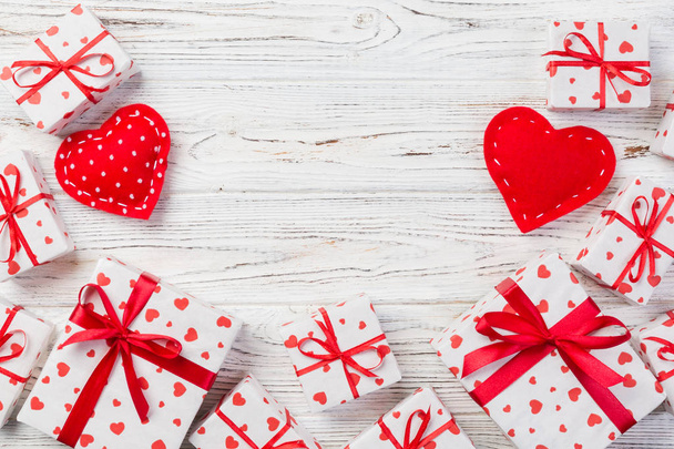 San Valentín u otro regalo hecho a mano en papel con corazones rojos y caja de regalos en envoltorio de vacaciones. Presente caja de regalo en vista superior de mesa de madera blanca con espacio para copiar, espacio vacío para el diseño
. - Foto, Imagen