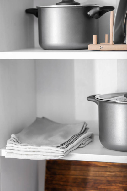 saubere Handtücher mit Geschirr in den Regalen - Foto, Bild