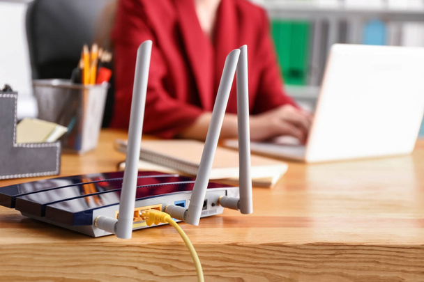 Moderní wi-fi router na dřevěný stůl v kanceláři - Fotografie, Obrázek