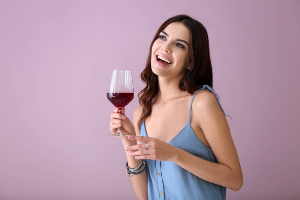 Beautiful young woman with glass of wine on color background - Fotografie, Obrázek